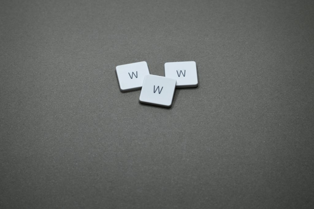 Three white letter tiles with 'W' on a gray surface, minimalist design
