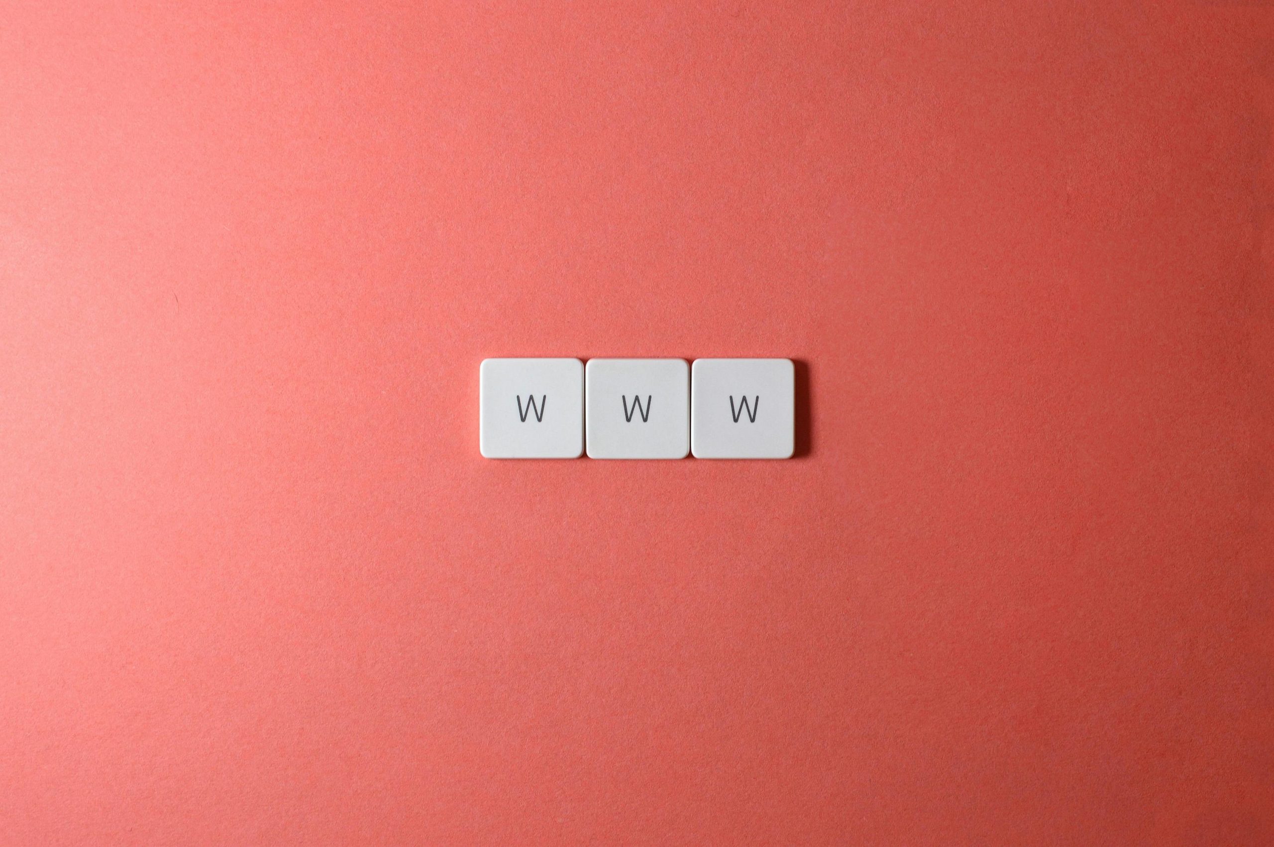 Close-up of WWW keyboard keys on a vibrant red surface, ideal for digital concepts.