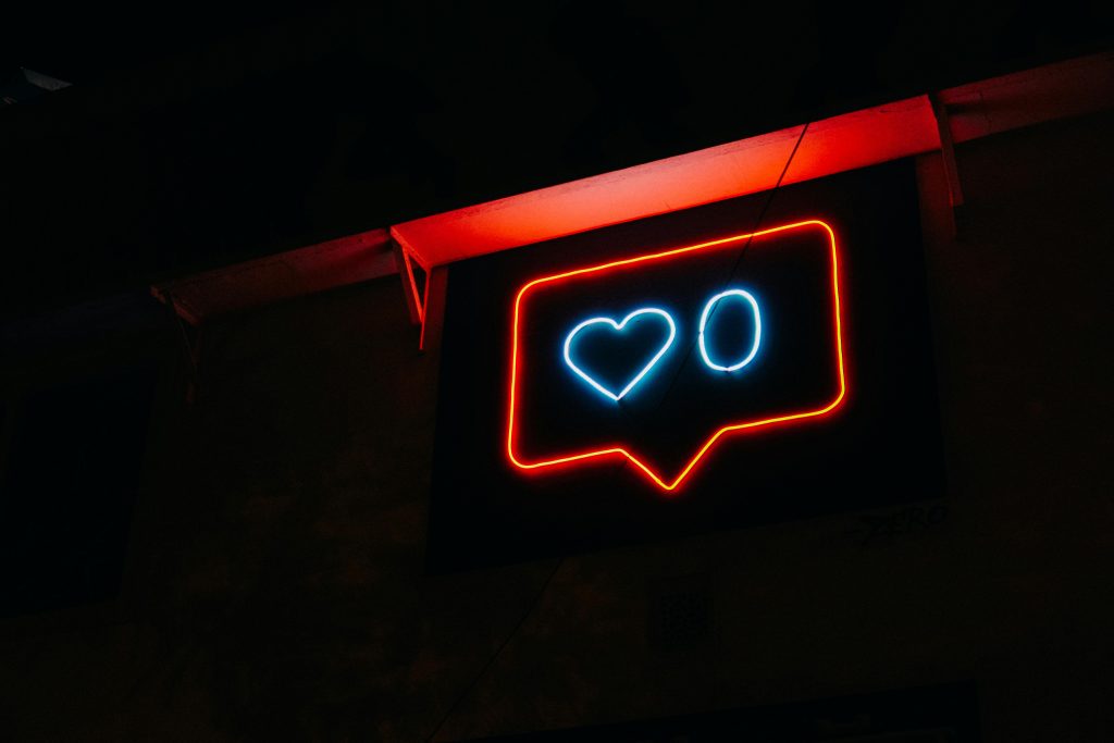 Bright neon heart icon with zero likes, symbolizing social media engagement.