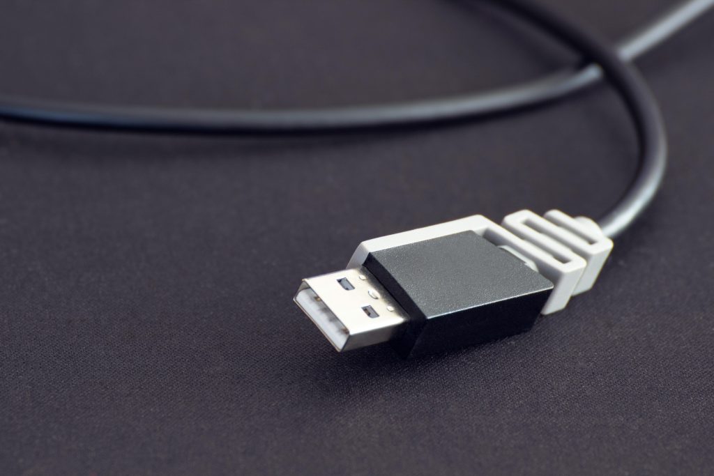 Detailed close-up of a black USB cable with a black background, highlighting connectivity technology.