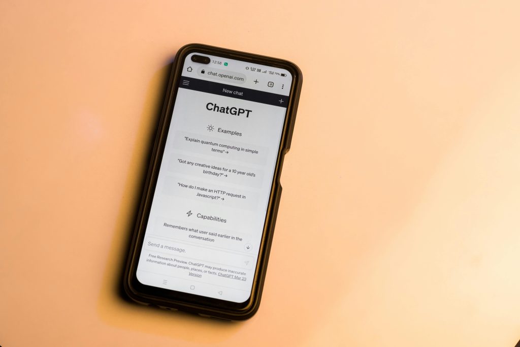 Smartphone showing ChatGPT website with warm tone, highlighting AI technology.